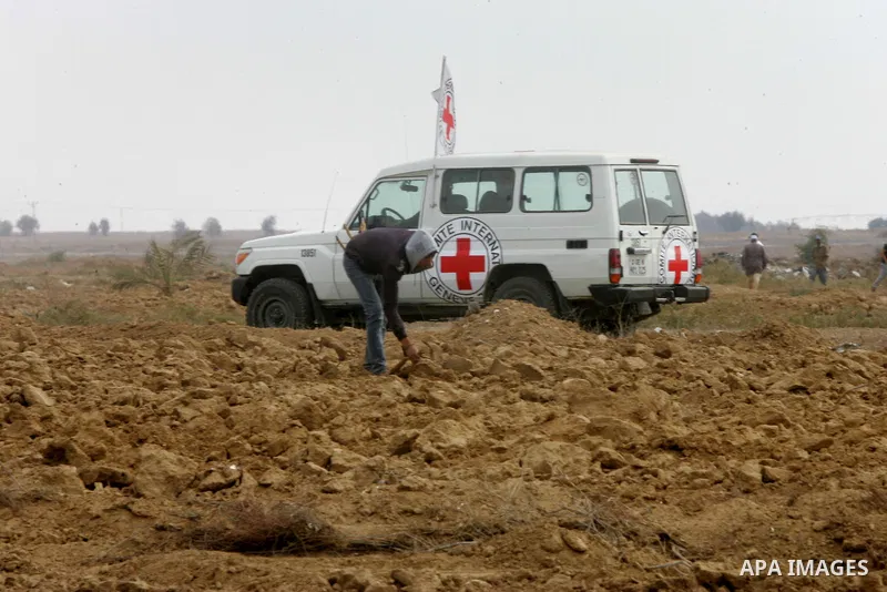 A man walks near an International Committee of the Red Cross (ICRC) vehicle as the comittee assists Palestinian farmers to repair their fields that were devastated during the Israeli army summer's military offensive on t...