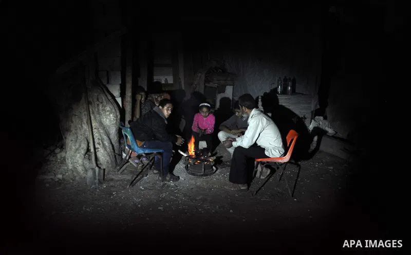 Palestinians warm themselves around a fire, at their destroyed house in al-Shejaiya neighbourhood in the east of Gaza City, October 23, 2014. With the cold days of winter approaching, more than 100,000 Gaza residents are...
