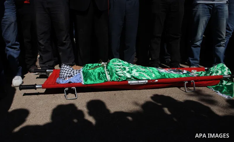 Mourners pray on the body of Palestinian-American youth Orwah Hammad, whom medics said was killed by Israeli forces, during his funeral in the West Bank village of Silwad near Ramallah October 26, 2014. Israeli forces sh...