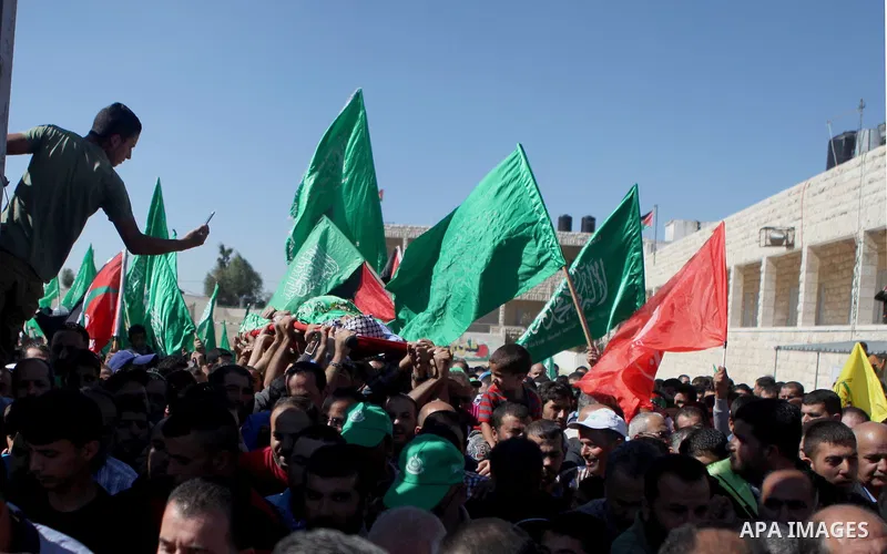 Mourners carry the body of Palestinian-American youth Orwah Hammad, whom medics said was killed by Israeli forces, during his funeral in the West Bank village of Silwad near Ramallah October 26, 2014. Israeli forces shot...