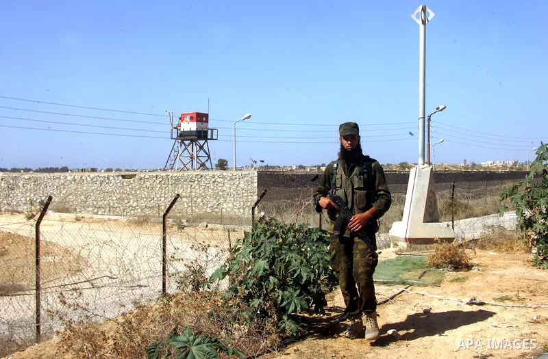 A Palestinian security officer stands guard while an Egyptian soldier (background) mans a watch tower on the Egyptian side, at the Rafah border crossing in the southern Gaza Strip October 26, 2014. The decision was taken...