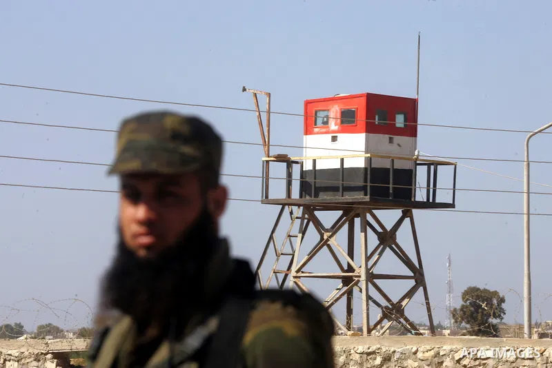 A Palestinian security officer stands guard while an Egyptian soldier (background) mans a watch tower on the Egyptian side, at the Rafah border crossing in the southern Gaza Strip October 26, 2014. The decision was taken...
