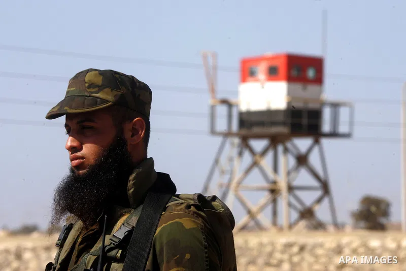 A Palestinian security officer stands guard while an Egyptian soldier (background) mans a watch tower on the Egyptian side, at the Rafah border crossing in the southern Gaza Strip October 26, 2014. The decision was taken...