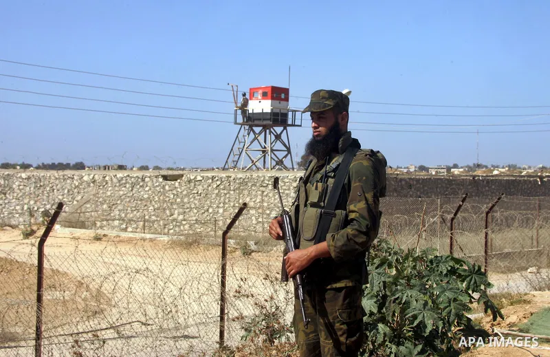 A Palestinian security officer stands guard while an Egyptian soldier (background) mans a watch tower on the Egyptian side, at the Rafah border crossing in the southern Gaza Strip October 26, 2014. The decision was taken...