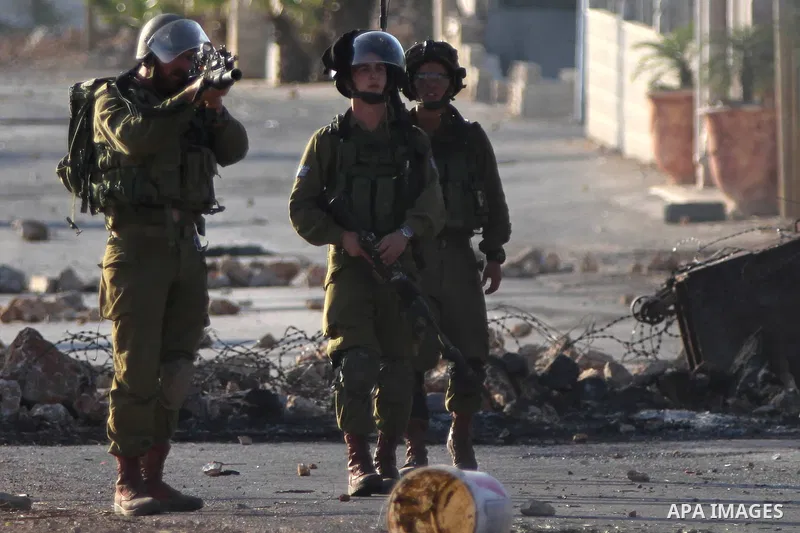 An Israeli security officer fires a tear gas canister during clashes with Palestinians after funeral Palestinian-American, Orwah Hammad, 14, who was shot dead last Friday during clashes with Israeli army soldiers, at the...