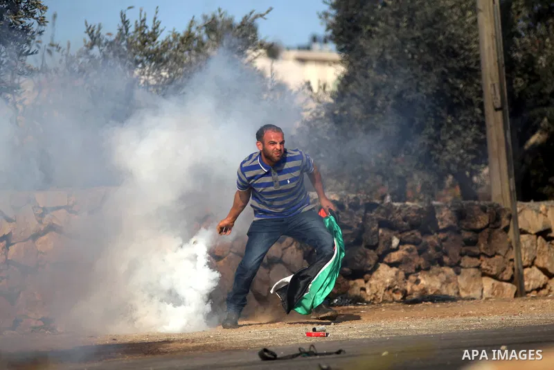 A Palestinian youth throws back a tear gas canister fired by Israeli security forces during clashes after funeral Palestinian-American, Orwah Hammad, 14, who was shot dead last Friday during clashes with Israeli army sol...