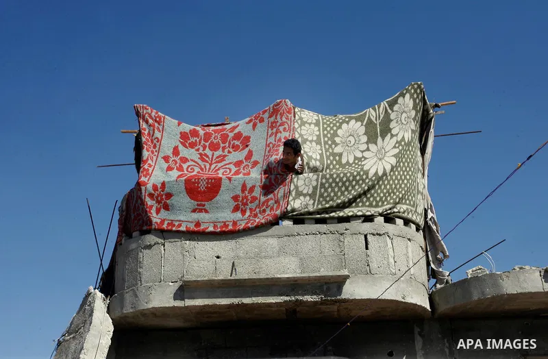 A Palestinian man looks from a destroyed house which witnesses said was destroyed by Israeli forces during the most recent conflict between Israel and Hamas, in Khuzaa in the east of Khan Younis, in the southern Gaza Str...