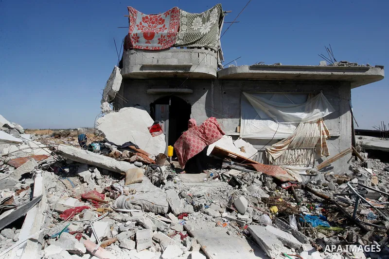 A Palestinian woman removes her belongings amongst the rubble of house which witnesses said was destroyed by Israeli forces during the most recent conflict between Israel and Hamas, in Khuzaa in the east of Khan Younis,...