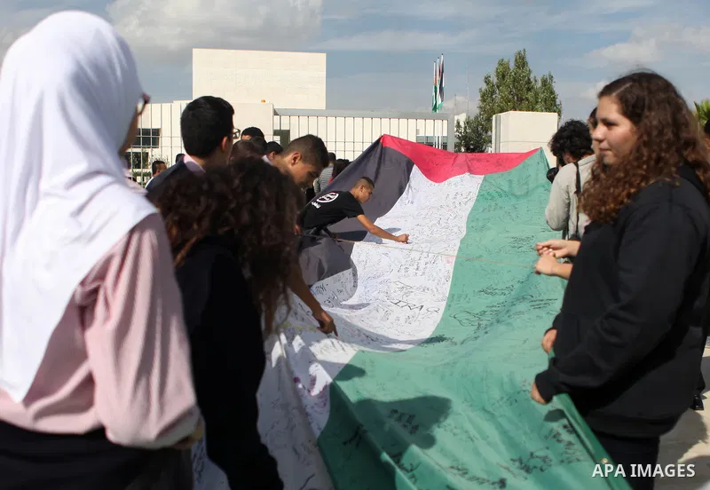 People march as they hold a large Palestinian flag during an attempt to break the Guinness World Record for the "largest Palestinian flag", in the West Bank city of Ramallah October 28, 2014. Photo by Shadi Hatem