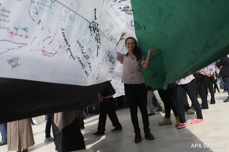 People march as they hold a large Palestinian flag during an attempt to break the Guinness World Record for the "largest Palestinian flag", in the West Bank city of Ramallah October 28, 2014. Photo by Shadi Hatem