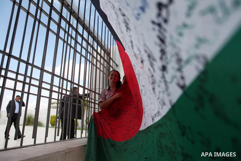 People march as they hold a large Palestinian flag during an attempt to break the Guinness World Record for the "largest Palestinian flag", in the West Bank city of Ramallah October 28, 2014. Photo by Shadi Hatem