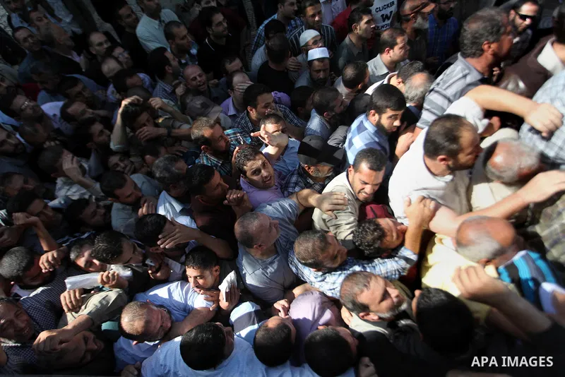 Employees of former Palestinian government in Gaza Strip wait to receive their salaries at a Post Office in Gaza city on October 29, 2014. The Palestinian national unity government headed by prime minister Rami Hamdallah...