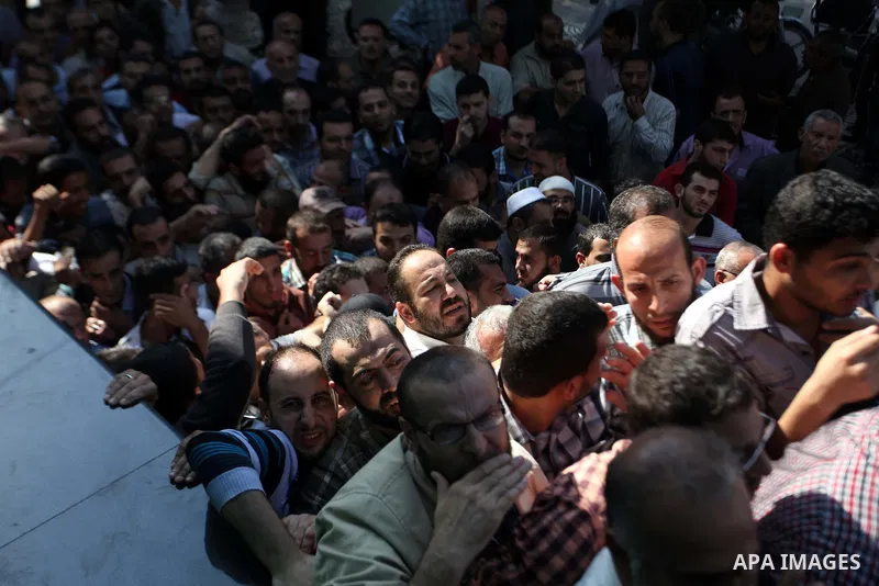 Employees of former Palestinian government in Gaza Strip wait to receive their salaries at a Post Office in Gaza city on October 29, 2014. The Palestinian national unity government headed by prime minister Rami Hamdallah...
