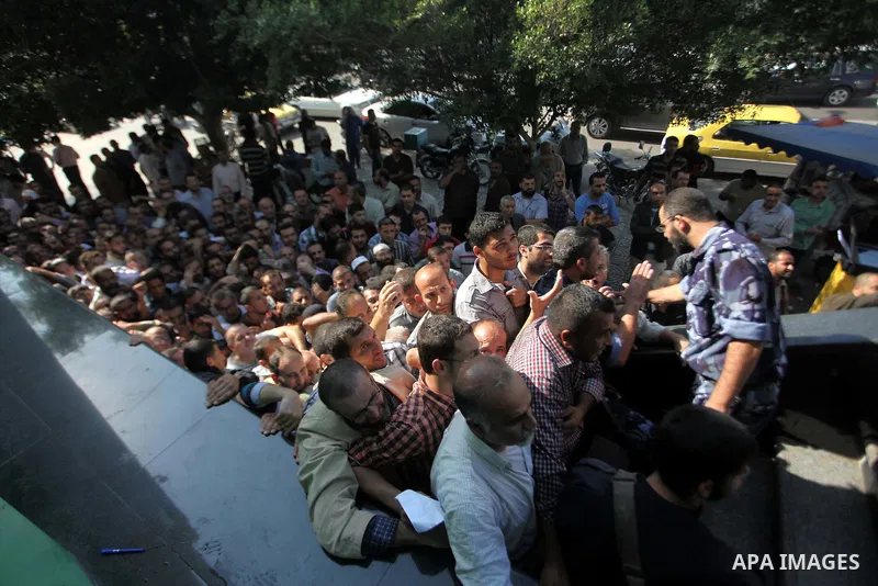 Employees of former Palestinian government in Gaza Strip wait to receive their salaries at a Post Office in Gaza city on October 29, 2014. The Palestinian national unity government headed by prime minister Rami Hamdallah...