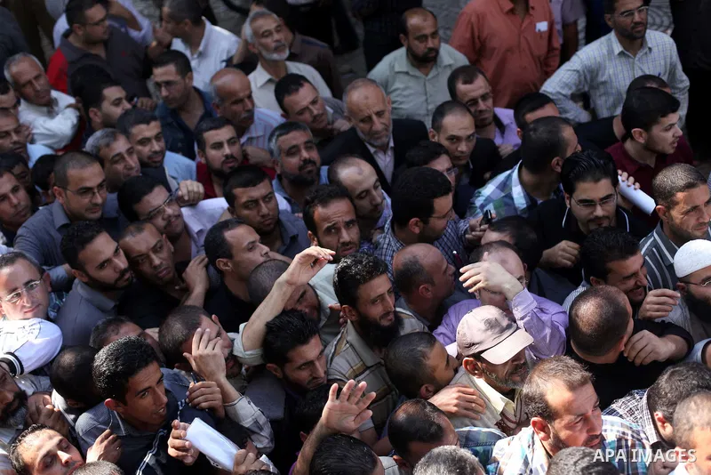 Employees of former Palestinian government in Gaza Strip wait to receive their salaries at a Post Office in Gaza city on October 29, 2014. The Palestinian national unity government headed by prime minister Rami Hamdallah...