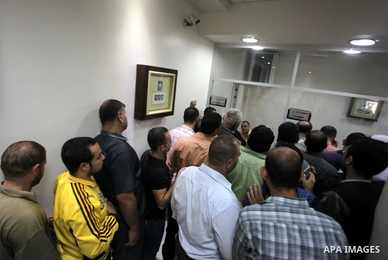 Employees of former Palestinian government in Gaza Strip wait to receive their salaries at a Post Office in Gaza city on October 29, 2014. The Palestinian national unity government headed by prime minister Rami Hamdallah...