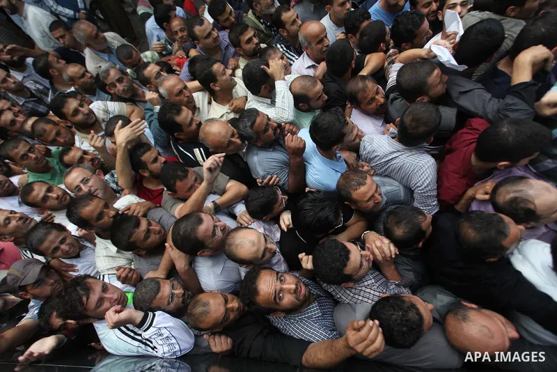 Employees of former Palestinian government in Gaza Strip wait to receive their salaries at a Post Office in Gaza city on October 29, 2014. The Palestinian national unity government headed by prime minister Rami Hamdallah...