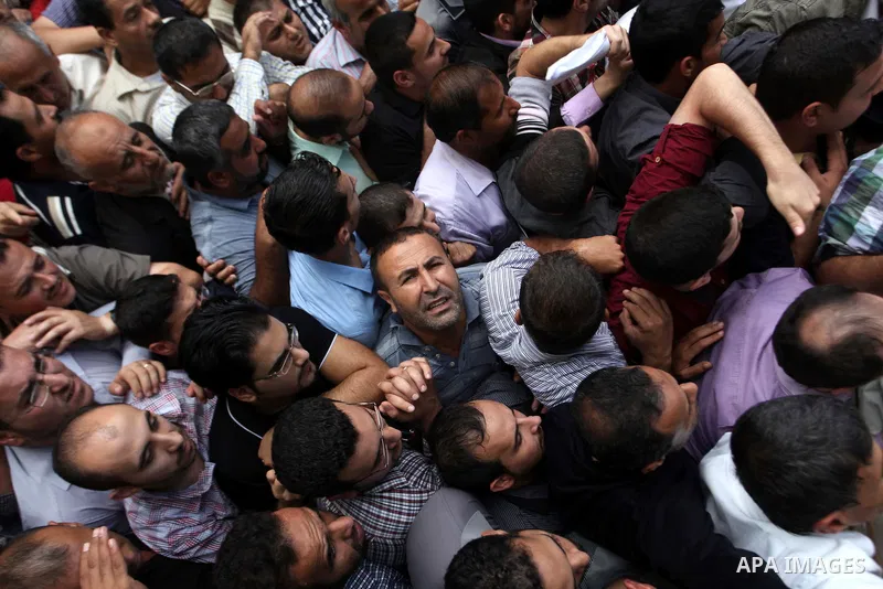 Employees of former Palestinian government in Gaza Strip wait to receive their salaries at a Post Office in Gaza city on October 29, 2014. The Palestinian national unity government headed by prime minister Rami Hamdallah...