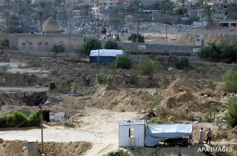 Palestinians look on as Egyptian security forces take part in a military operation to demolish some buildings in the Egyptian city of Rafah near the border with southern Gaza Strip October 29, 2014, as Egypt began settin...