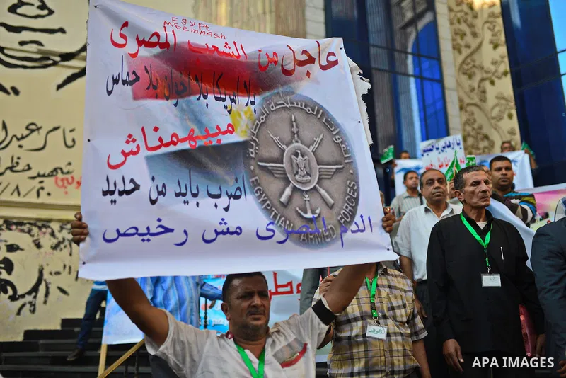 Egyptians hold placards and shout slogans during a rally to show solidarity with Egyptian army and President Abdel Fattah al-Sisi, outside the journalists syndicate, in Cairo on October 29, 2014, as Egypt began setting u...