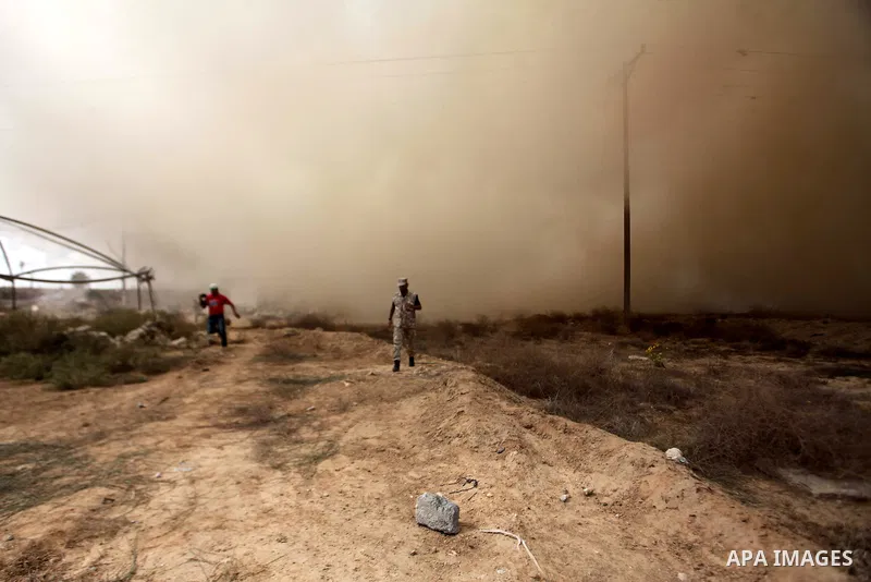 A Palestinian security officer runs as smoke rises after a house is blown up during a military operation by Egyptian security forces in the Egyptian city of Rafah, near the border with the southern Gaza Strip on October...