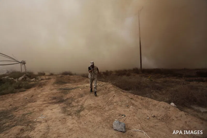 A Palestinian security officer runs as smoke rises after a house is blown up during a military operation by Egyptian security forces in the Egyptian city of Rafah, near the border with the southern Gaza Strip on October...