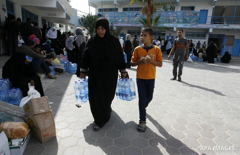 Displaced Palestinians receive food suplies at a UN school, in Rafah in the southern Gaza Strip, October 31, 2014. The International Labor Organization (ILO) said on Wednesday that several specialists from its team are s...