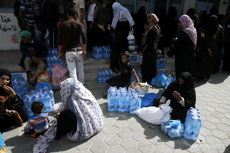 Displaced Palestinians receive food suplies at a UN school, in Rafah in the southern Gaza Strip, October 31, 2014. The International Labor Organization (ILO) said on Wednesday that several specialists from its team are s...
