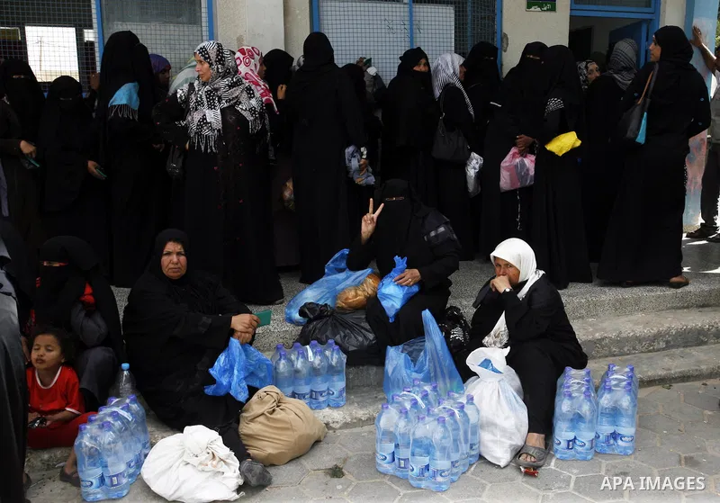 Displaced Palestinians receive food suplies at a UN school, in Rafah in the southern Gaza Strip, October 31, 2014. The International Labor Organization (ILO) said on Wednesday that several specialists from its team are s...
