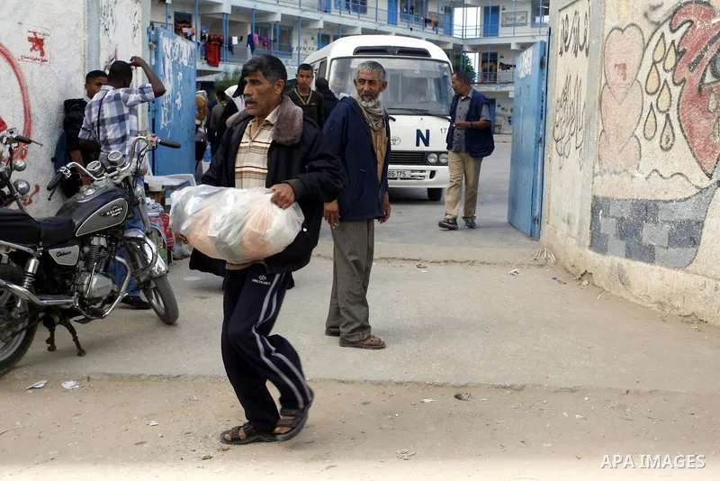 Displaced Palestinians receive food suplies at a UN school, in Rafah in the southern Gaza Strip, October 31, 2014. The International Labor Organization (ILO) said on Wednesday that several specialists from its team are s...