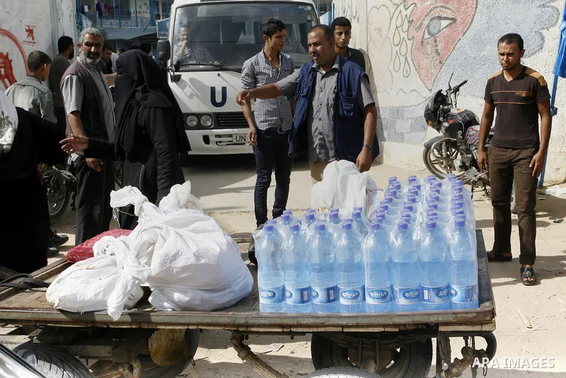 Displaced Palestinians receive food suplies at a UN school, in Rafah in the southern Gaza Strip, October 31, 2014. The International Labor Organization (ILO) said on Wednesday that several specialists from its team are s...