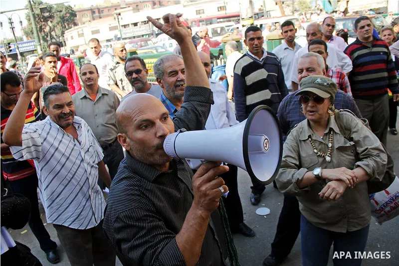 Pro-deposed president Hosni Mubarak Egyptians hold placards during a protest demanding the trial of the revolution leaders, outside the court of cassation, in Cairo on October 30, 2014. Photo by Amr Sayed