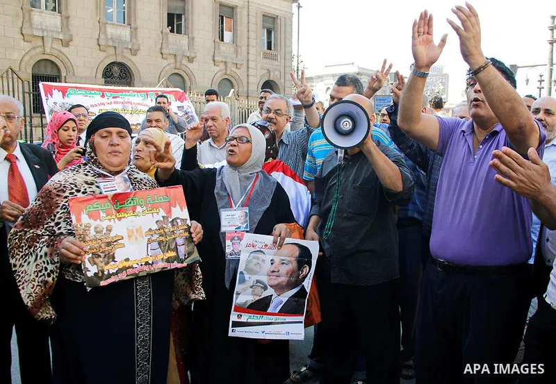 Pro-deposed president Hosni Mubarak Egyptians hold placards during a protest demanding the trial of the revolution leaders, outside the court of cassation, in Cairo on October 30, 2014. Photo by Amr Sayed