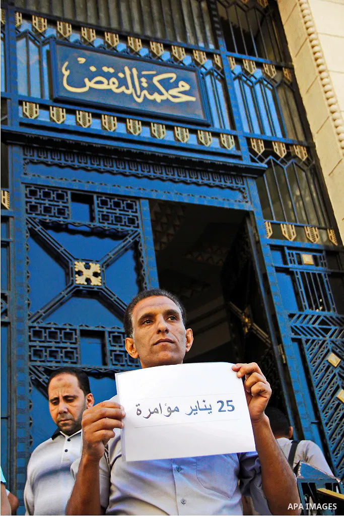 Pro-deposed president Hosni Mubarak Egyptians hold placards during a protest demanding the trial of the revolution leaders, outside the court of cassation, in Cairo on October 30, 2014. Photo by Amr Sayed