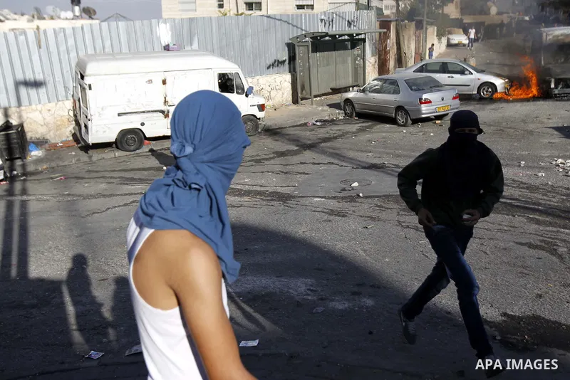 Palestinian youth throw stones towards Israeli security forces during clashes after Moataz Higazi was shot in east Jerusalem October 30, 2014. Israeli police shot and killed Higazi suspected of trying to kill a hard-line...