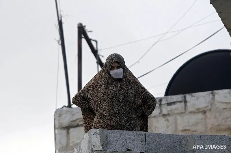 A Palestinian woman looks on from her house roof during clashes between Palestinian youths and Israeli security forces after Moataz Higazi was shot in east Jerusalem October 30, 2014. Israeli police shot and killed Higaz...