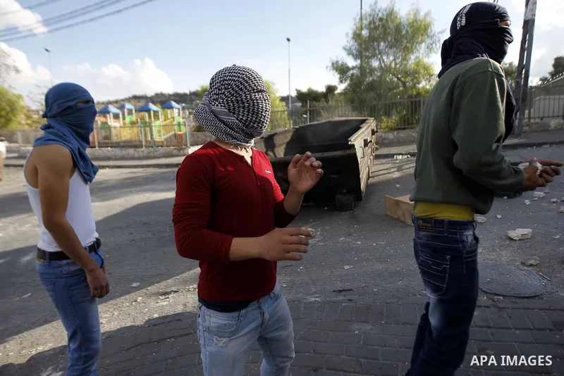 Palestinian youths take cover during clashes with Israeli security forces after Moataz Higazi was shot in east Jerusalem October 30, 2014. Israeli police shot and killed Higazi suspected of trying to kill a hard-line Jew...
