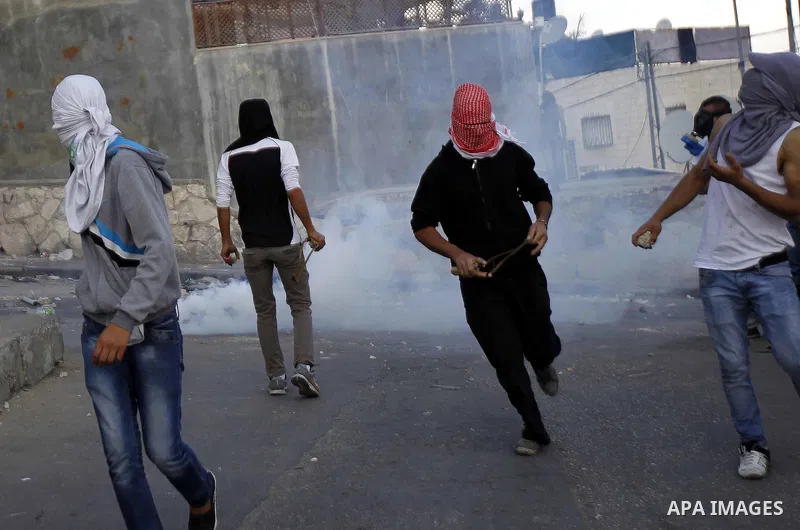 Palestinian youths run for cover from tear gas fired by Israeli security forces during clashes after Moataz Higazi was shot in east Jerusalem October 30, 2014. Israeli police shot and killed Higazi suspected of trying to...