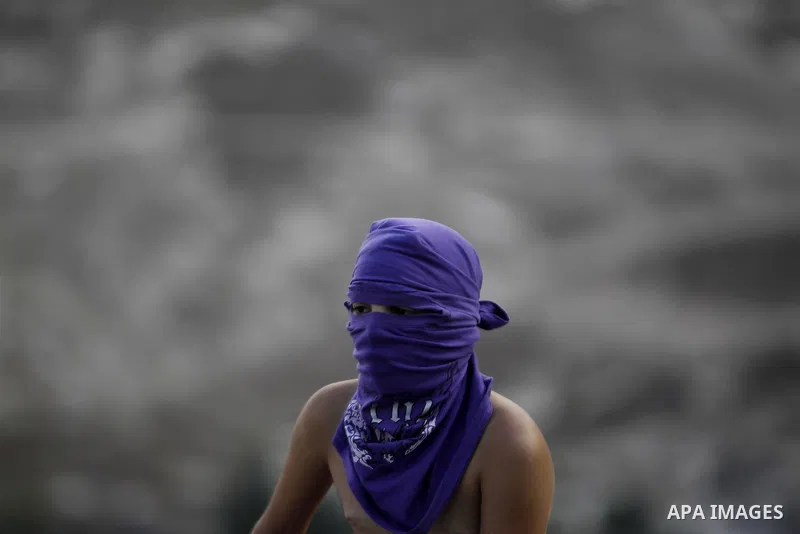 A masked Palestinian youth looks on during clashes with Israeli security forces after Moataz Higazi was shot in east Jerusalem October 30, 2014. Israeli police shot and killed Higazi suspected of trying to kill a hard-li...