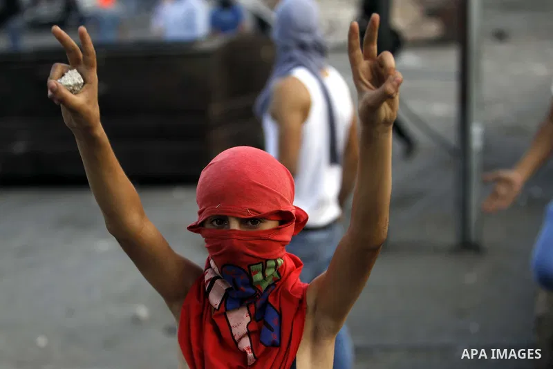 A masked Palestinian youth flashes victory sign during clashes with Israeli security forces after Moataz Higazi was shot in east Jerusalem October 30, 2014. Israeli police shot and killed Higazi suspected of trying to ki...