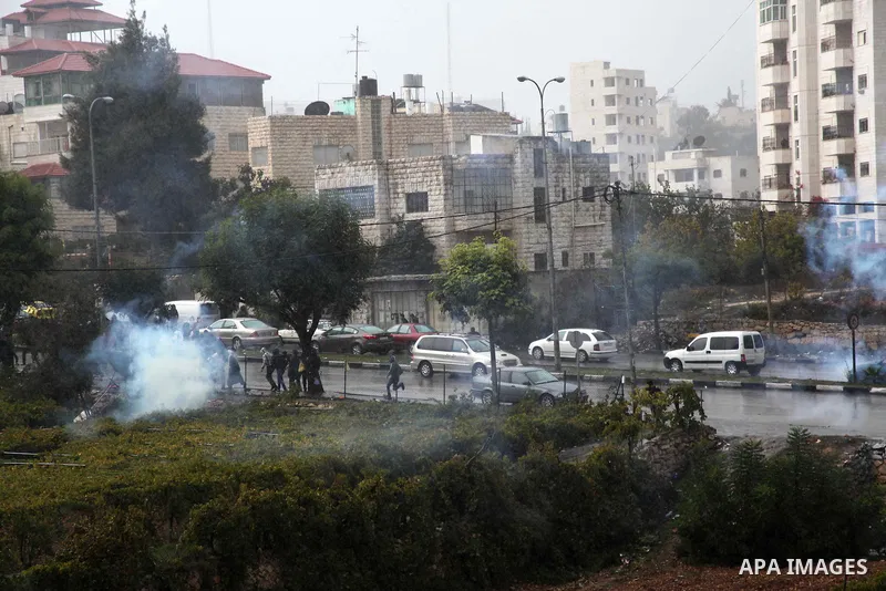 Palestinian youths throw stones towards Israeli security forces during clashes in a protest against Israeli restrictions at the Al-Aqsa Mosque compound, and in solidarity with the people in Jerusalem, in the West Bank Ci...