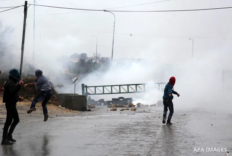 Palestinian youths throw stones towards Israeli security forces during clashes in a protest against Israeli restrictions at the Al-Aqsa Mosque compound, and in solidarity with the people in Jerusalem, in the West Bank Ci...