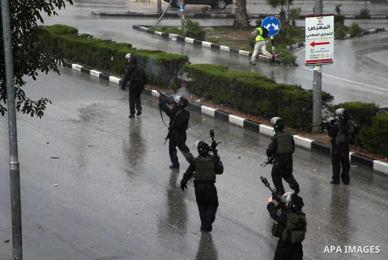 Israeli security forces take position during clashes with Palestinian youths in a protest against Israeli restrictions at the Al-Aqsa Mosque compound, and in solidarity with the people in Jerusalem, in the West Bank City...