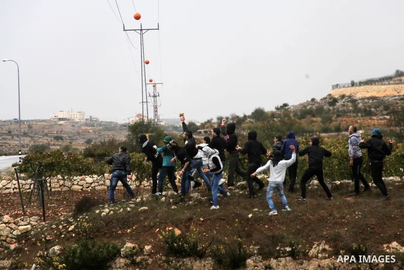 Palestinian youths throw stones towards Israeli security forces during clashes in a protest against Israeli restrictions at the Al-Aqsa Mosque compound, and in solidarity with the people in Jerusalem, in the West Bank Ci...
