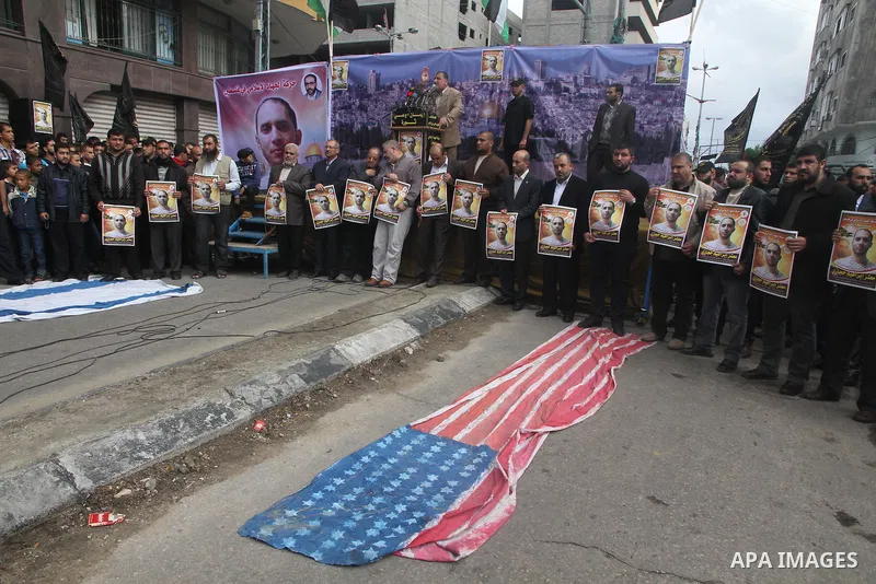 Palestinians burn a U.S flag and an Israeli flag during an anti-Israel rally organised by the Islamic Jihad movement over the entry restrictions to the al-Aqsa mosque, in Gaza City October 31, 2014. Muslim men over 50 pr...