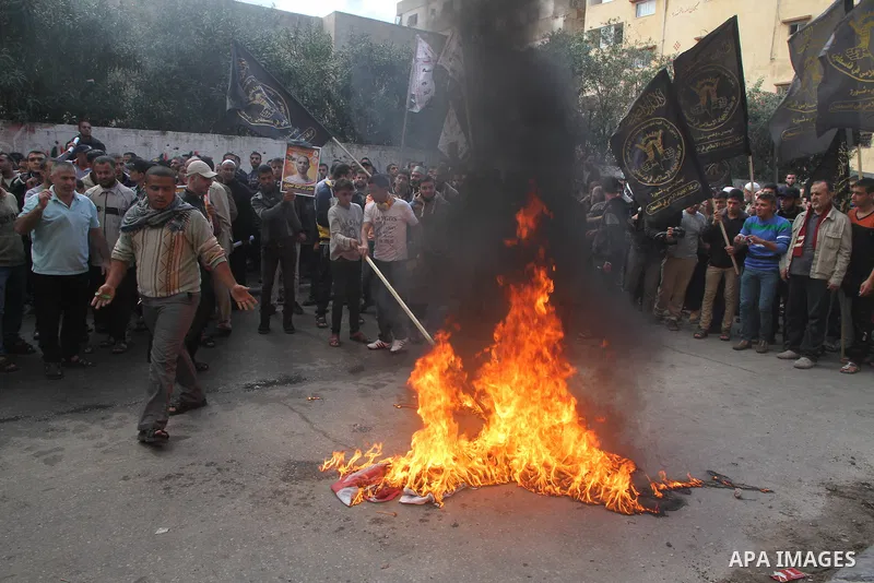 Palestinians burn a U.S flag and an Israeli flag during an anti-Israel rally organised by the Islamic Jihad movement over the entry restrictions to the al-Aqsa mosque, in Gaza City October 31, 2014. Muslim men over 50 pr...