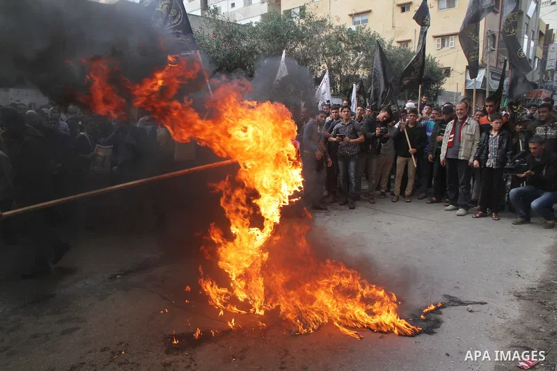 Palestinians burn a U.S flag and an Israeli flag during an anti-Israel rally organised by the Islamic Jihad movement over the entry restrictions to the al-Aqsa mosque, in Gaza City October 31, 2014. Muslim men over 50 pr...