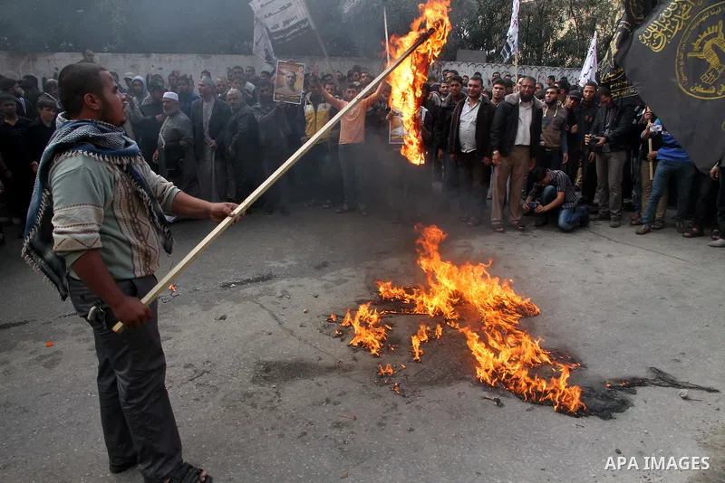 Palestinians burn a U.S flag and an Israeli flag during an anti-Israel rally organised by the Islamic Jihad movement over the entry restrictions to the al-Aqsa mosque, in Gaza City October 31, 2014. Muslim men over 50 pr...