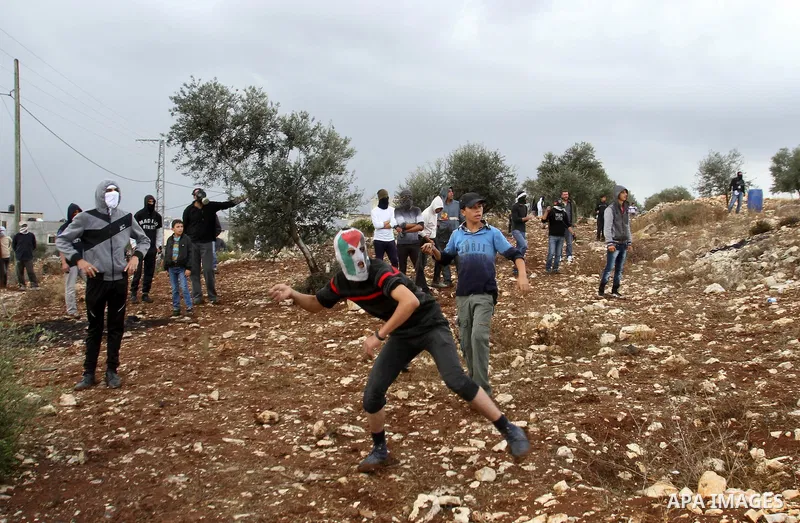 Palestinian protesters throw stones towards Israeli security forces during clashes following a weekly demonstration against the expropriation of Palestinian land by Israel in the village of Kafr Qaddum, near Nablus, in t...