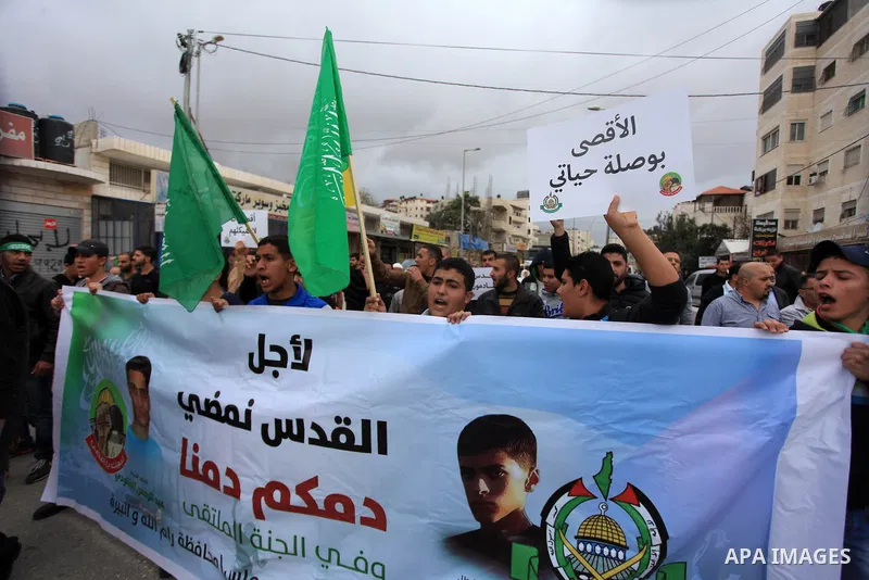 Palestinian Hamas movement supporters hold placards during a demonstration against the restrictions on the Al-Aqsa mosque compound, at the Qalandia checkpoint between Ramallah and Jerusalem City on October 31, 2014. Clas...
